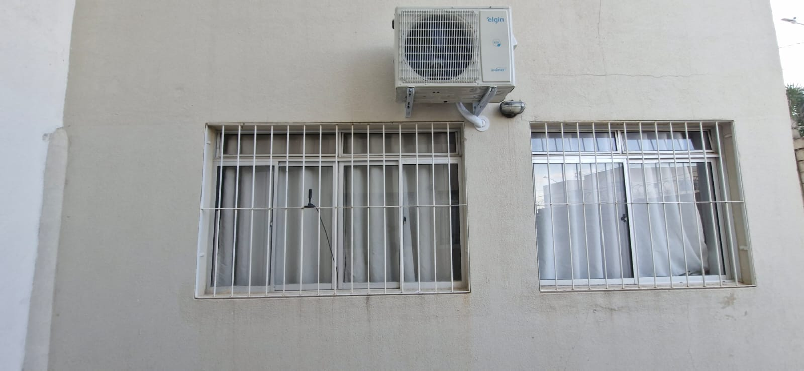Condensadora Elgin Inverter fixada acima das janelas